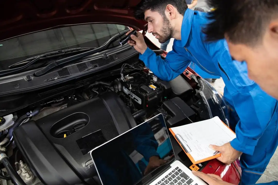 Technician performing post repair inspection on a recently repaired vehicle